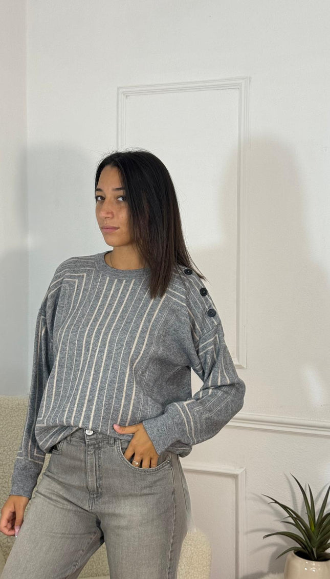 Maglione a righe verticali grigio bianco con bottoni scuri sulla spalla e collo rotondo